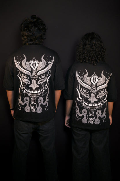 Two people wearing black t-shirts with white graphic designs on the back against a dark background.
